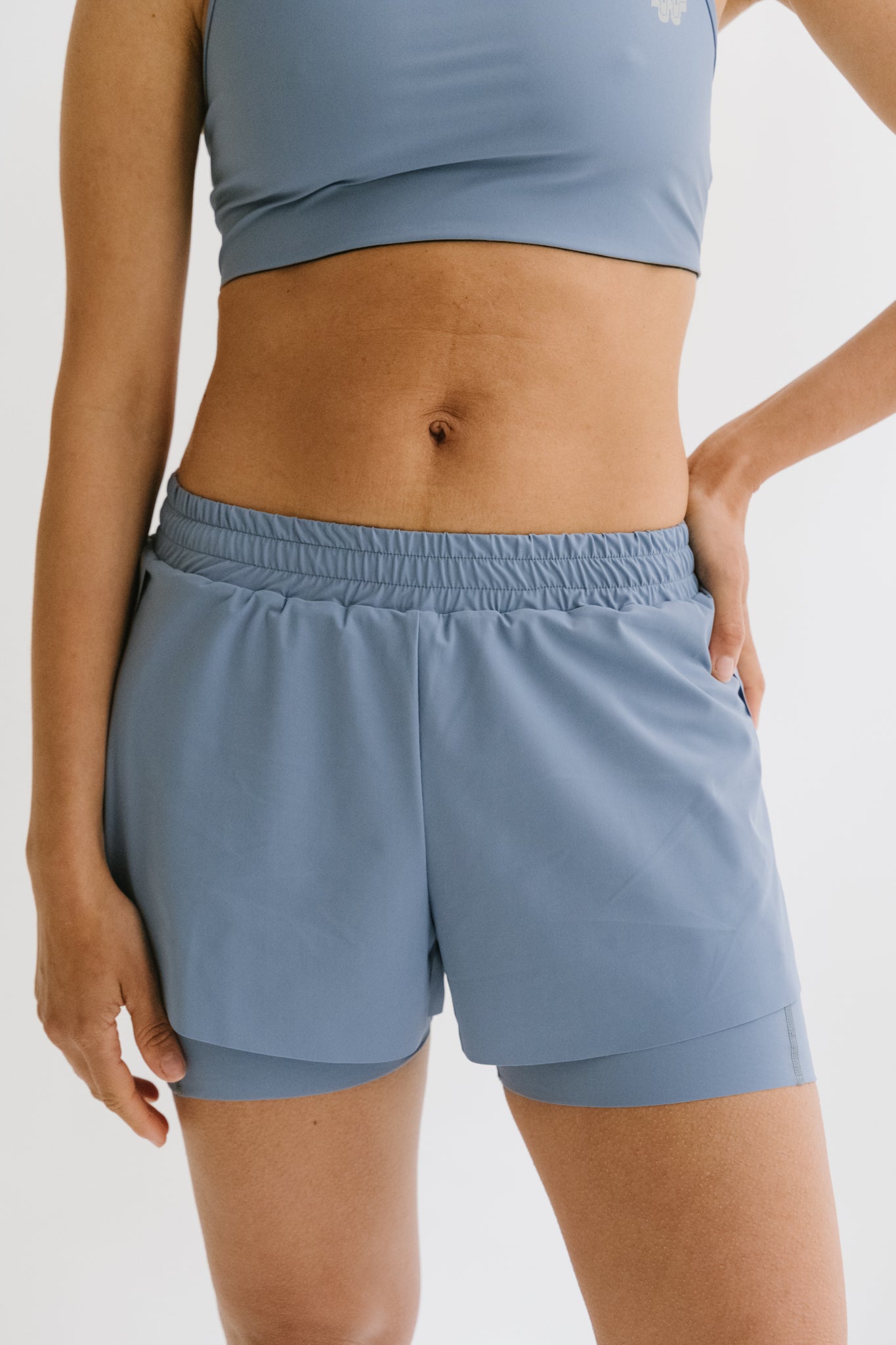 Coureuse portant le short de running Rachel en bleu, vue de face, mettant en évidence sa coupe ajustée et sa légèreté. #color_Bleu