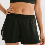 Vue de face d'une femme portant le short de running Rachel en noir, soulignant la ceinture élastique et le design ergonomique. #color_Noir